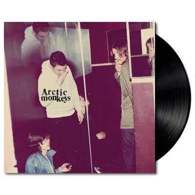 Vinyl record with a cover featuring band members in a room, with 'Arctic Monkeys' text.
