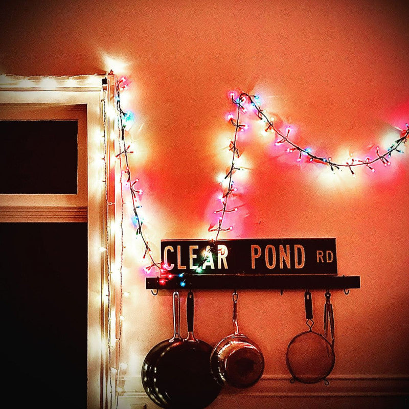 A photo of Kristin Hersh's Clear Pond Road album on clear vinyl LP, displayed in a home setting with Christmas lights in the background.